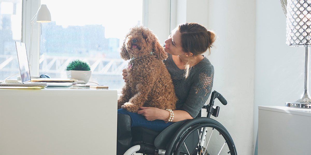Woman in wheelchair with dog on her lap