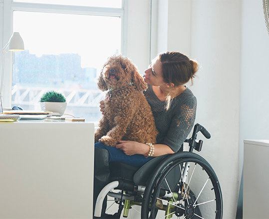 Woman in wheelchair with dog on her lap