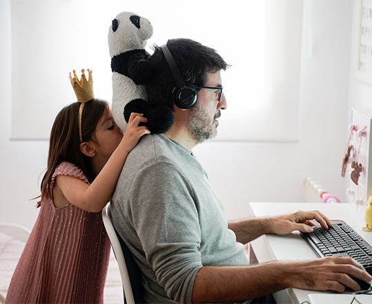 コンピューターに向かう男性とその背後にいる子供。