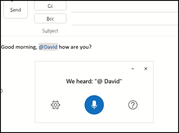 Screenshot showing the @mention voice command feature in Outlook's email dictation functionality