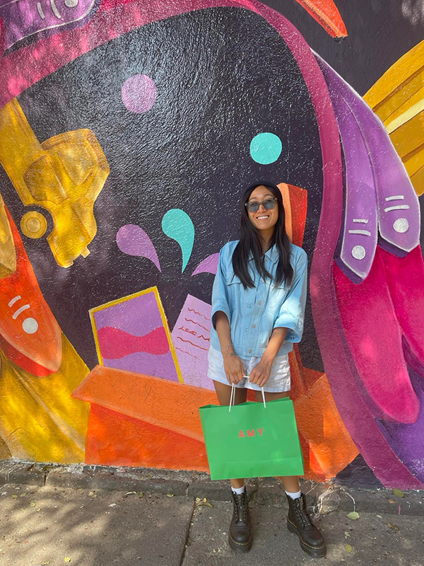 Aimee Leong with a colorful mural backdrop